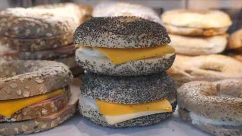 Fresh bagels displayed in bakery showcase with poppy seeds cheese and ham b.. Stock Footage 331914284