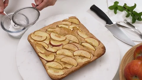 Fresh baked Apple pie on a serving board. Topping cake with powdered sugar. Stock Footage 129199316