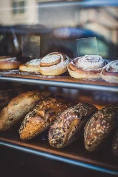 Fresh Baked Bread and Cinnamon Rolls in the Window of a Bakery Stock Photos