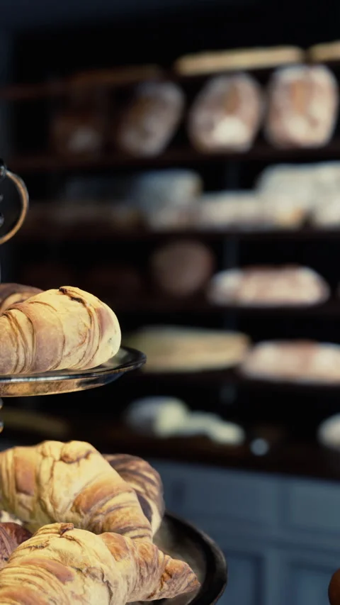 Fresh baked bread and pastries on display in a bakery shop setting Stock Footage 340632956