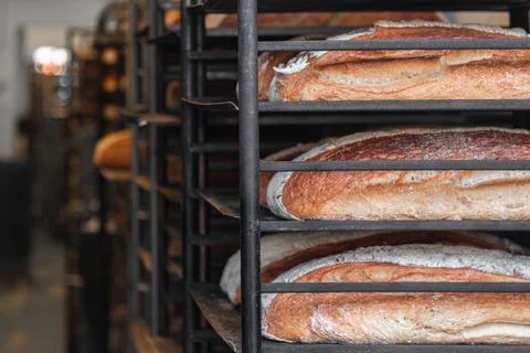Fresh baked bread lined u on iron metal racking ready for the market Stock Photos