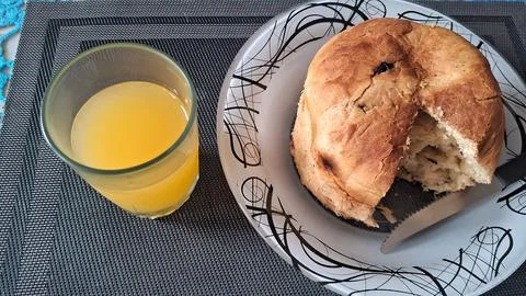 Fresh baked bread roll served with glass of orange juice Fotos de archivo