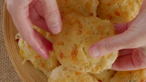 Fresh baked cheese biscuits close-up on a wooden plate, flat lay Stock Footage 230517182