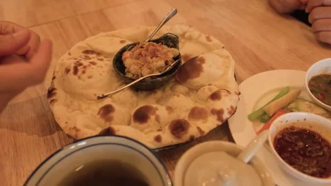 Fresh Baked Naan Bread and Dipping Sauces on Wooden Table Stock Footage 345457899