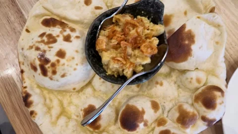 Fresh Baked Naan Bread Served with Chickpea Curry and Fried Onions Stock Footage 345099860