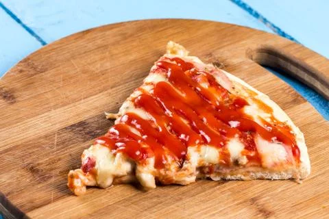 Fresh baked pizza triangle slice with cheese tomato sauce mushrooms on the ro Stock Photos