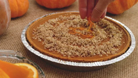 Fresh baked pumpkin pie close up. Decorating pie with orange zest. Stock Footage 149406770