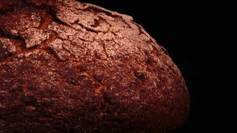 Fresh baked round bread rotating against black background. 4k 動画素材 73087944
