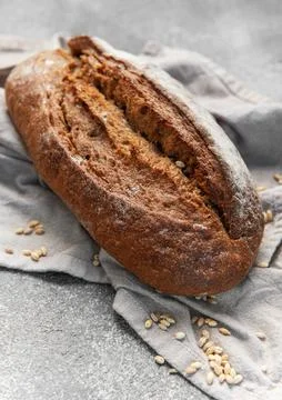 Fresh baked rustic dark bread loaf on towel Stock Photos