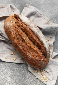 Fresh baked rustic dark bread loaf on towel Stock Photos
