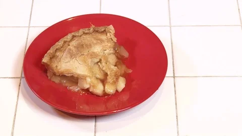 A fresh baked slice of apple pie steams on a red plate. Video stock 107478263