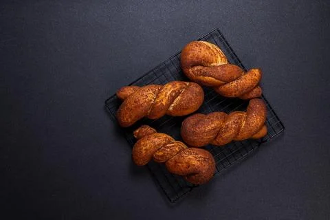 Fresh baked twisted bread rolls cooling on rack Foto stock