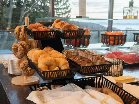 Fresh bakery buffet display with assorted croissants and bagels on tiered Stock Photos