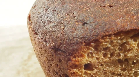 Fresh bakery loaf of bread on white background. Close up slow panorama. Stock Footage 50582223