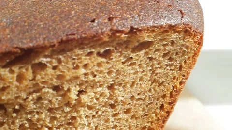 Fresh bakery loaf of bread on white background. Close up slow panorama. Stock Footage 50582242