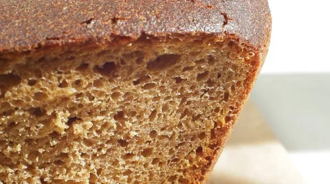 Fresh bakery loaf of bread on white background. Close up slow panorama. Stock Footage 50582265