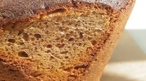 Fresh bakery loaf of bread on white background. Close up slow panorama. Stock Footage 50582276
