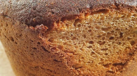 Fresh bakery loaf of bread on white background. Close up slow panorama. Stock Footage 50582302
