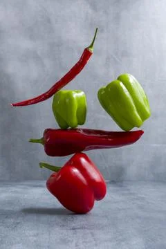 Fresh balancing peppers on table. Equilibrium floating food balance Stock Photos