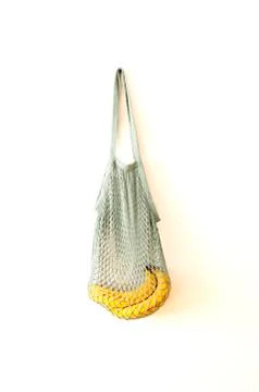 Fresh bananas in string bag on white wall, shadows, healthy fruits, Eco frien Stock Photos