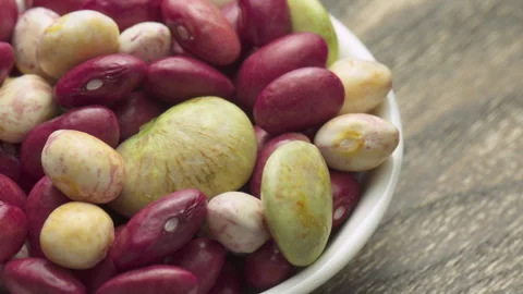 Fresh beans of different varieties and sizes on white plate Stock Footage 325641074