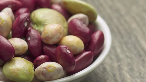 Fresh beans of different varieties and sizes on white plate Stock Footage 345380698