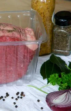 Fresh beef joint in a clear plastic tray with ingredients to prepare and cook 写真素材