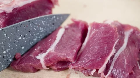 Fresh beef is sliced with sharp ceramic knife. Video stock 266649054