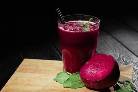 Fresh beetroot juice in glass with leaf on wooden table Stock Photos