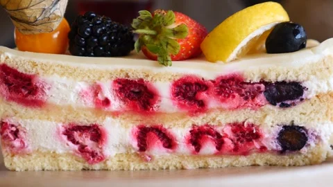 Fresh berry sponge cake slice on plate with creamy filling raspberries blue.. Stock Footage 332056920