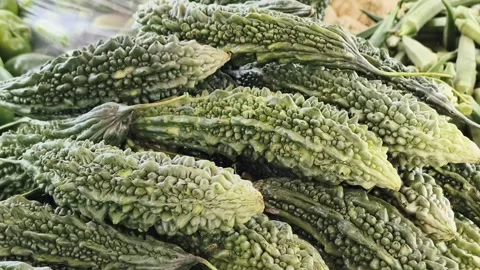 Fresh Bitter Gourd Displayed at Vegetable Market for Healthy Organic Nutriti Stock Footage 337875317