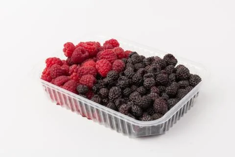 Fresh black and red raspberry in  plastic container isolated on white backgro Stock Photos