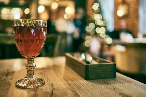 Fresh blackcurrant compote served in a multi-faceted glass on a wooden table Stock Photos