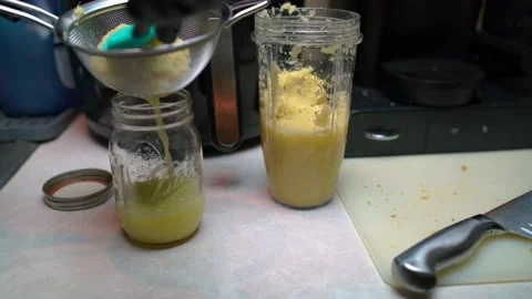 Fresh blended ginger for ginger shots squeezed into mason jar Stock Footage 225333847