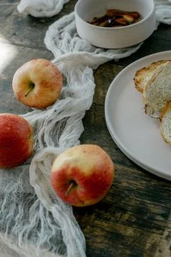 Fresh bread and apples on rustic table Stock Photos