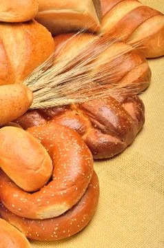 Fresh bread and wheat ear on the tablecloth Stock Photos