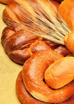 Fresh bread and wheat ear on tablecloth Stock Photos