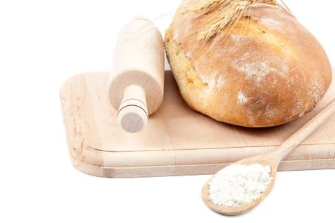 Fresh bread and wheat ears on a wooden board. Stock Photos