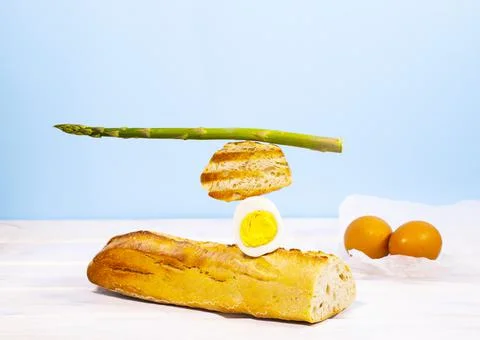 Fresh Bread, Asparagus and Egg. Breakfast. Equilibrium floating food. Stock Photos