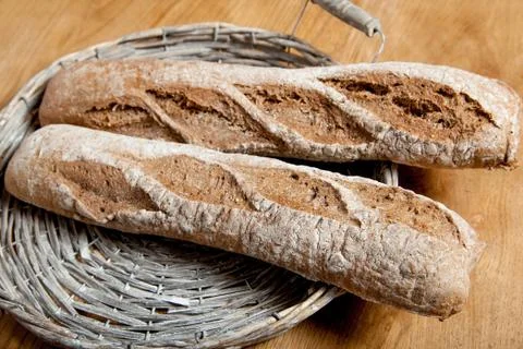 Fresh bread in a basket on a brown background Stock Photos