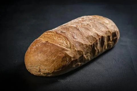 Fresh bread on a black kitchen table. Bread prepared for serving. Stock Photos