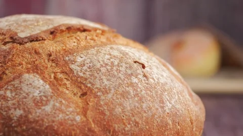 Fresh bread close up on wooden table in a warm kitchen Stock Footage 329011314