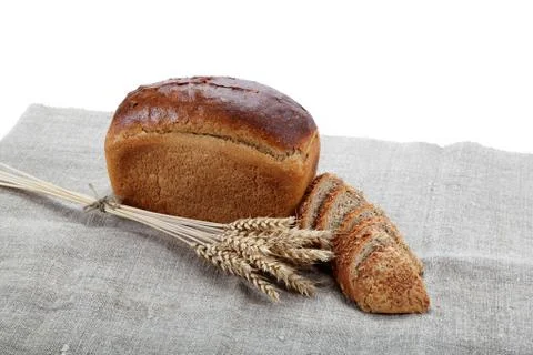 Fresh bread with ears of wheat on the canvas. Stock Photos