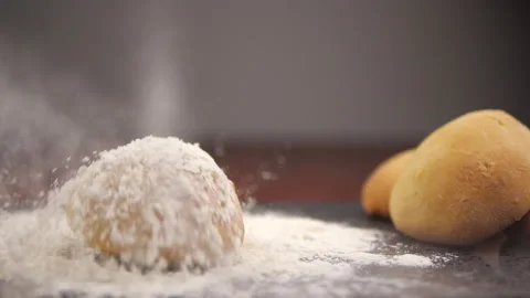 Fresh bread falling on table close-up in flour placer Stock Footage 131691851