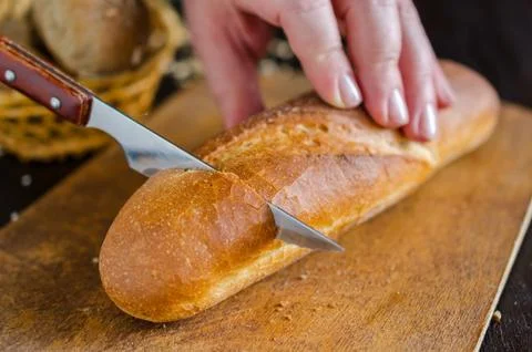 Fresh bread with kitchen knife on the kitchen. Healthy eating. Stock Photos