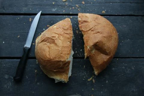 Fresh bread lies on a old table in the kitchen. Stock Photos