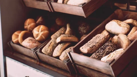 Fresh Bread Loaves and Rolls Displayed in Wooden Crates at a Local Bakery Shop Stock Footage 348248255