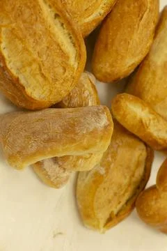 Fresh bread loaves arranged on table top-down, appetizing golden brown and soft. Stockfoto's