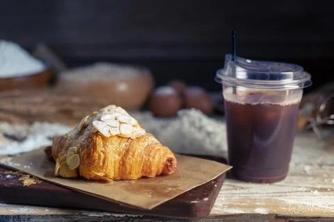 Fresh bread or croissants on a rustic wooden table With iced coffee   Simpl.. Stock Photos