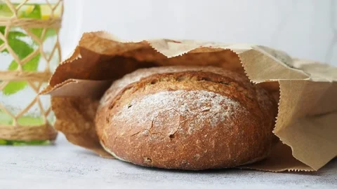 Fresh bread in a paper bag on a table Stock Footage 343652407